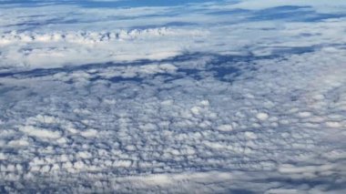 Mavi gökyüzü ve uçağın penceresinden görünen bulutlar irtifada seyrediyor. Kimse yok..