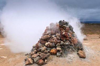 İzlanda 'da Hver' in jeotermal bölgesindeki kaplıcalarda dumanı tüten fümerol. 