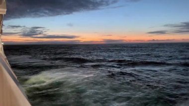 Gün batımında deniz manzarası. Okyanusu geçen bir yolcu gemisinin güvertesinden.