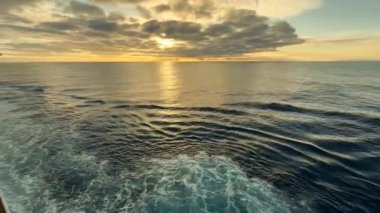 Gün batımında deniz manzarası. Okyanusu geçen bir yolcu gemisinin güvertesinden.