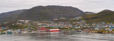 Qaqortoq, Grönland - 28 Ağustos 2024: Uzak Qaqortoq kasabasındaki liman ve renkli evlerin panoramik manzarası