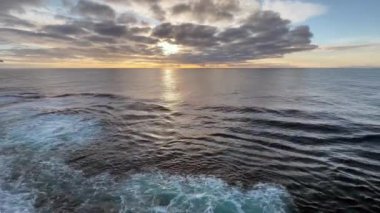 Gün batımında deniz manzarası. Okyanusu geçen bir yolcu gemisinin güvertesinden.