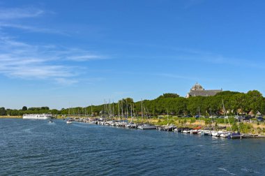 Veere, Zeeland, Hollanda - 10 Ağustos 2022: Veere kasabasında demirlemiş bir tekne ve nehir gezisi gemisinin manzarası.