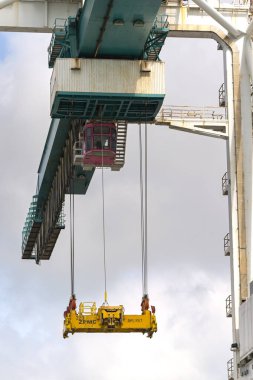 Miami, Florida, ABD - 1 Aralık 2023: Nakliye konteynırlarını taşımak için rıhtım tarafındaki vinçteki kapma mekanizması