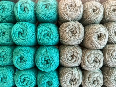 Bir örgü dükkanında sergilenen mavi ve bej yün toplarının görüntüsünü kapat..