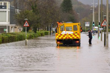 Treforest Industrial Estate, Wales, İngiltere - 24 Kasım 2024: Güney Galler 'de Treforest Industrial Estate' de sel basmış bir yoldaki Lorry 'de taşkın sularında yürüyen bir kişi.
