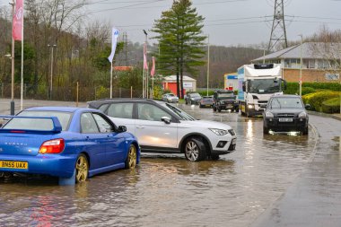Treforest Industrial Estate, Wales, İngiltere - 24 Kasım 2024: Şiddetli yağmur sonrasında kıyılarını patlattıktan sonra Şekerleme Nehri 'nin taşkın sularından geçmeye çalışan trafik