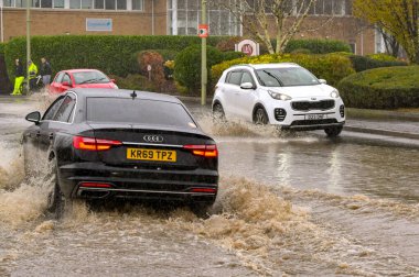Treforest Industrial Estate, Wales, İngiltere - 24 Kasım 2024: Şiddetli yağmur sonrasında kıyılarını patlatan araçlar Şekerleme Nehri 'nden sel sularını geçiyor