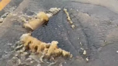 Şiddetli bir yağmurdan sonra lağımdan kahverengi su fışkırıyor. İnsan yok, aşırı hava konsepti.