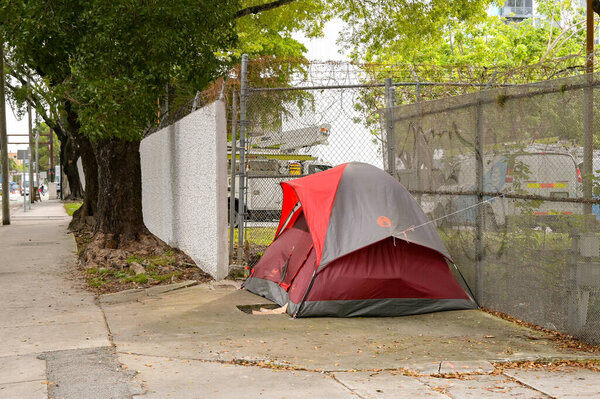 Miami, Florida, USA - 2 December 2023: Tent of a homeless person on the sidewalk in downtown Miami