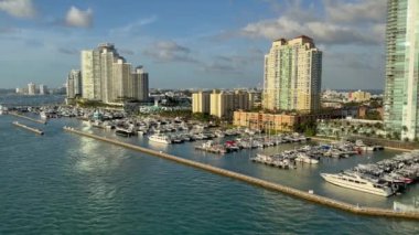 Miami, Florida, ABD 4 Ocak 2025: Miami Beach yakınlarındaki marinada tekne ve yatlar yüksek apartman ve apartman bloklarının önünde.