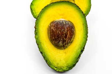 Close up of a ripe avocado cut in half isolated on a plain white background.  clipart