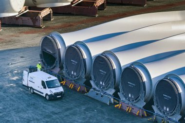 Le Havre, Fransa, Avrupa - 16 Ocak 2025: Siemens 'in Le Havre Limanı' ndaki rıhtımda depoladığı büyük rüzgar türbini bıçakları ve ölçeklendirme için yanında bir minibüs..