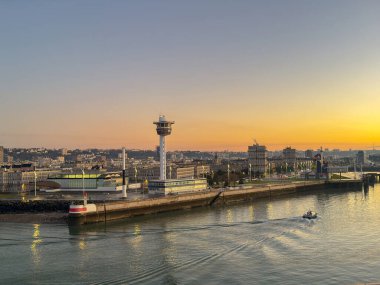 Le Havre, France, Europe - 16 January 2025: Entrance to the port of Le Havre with the shipping control tower on the waterfront at dawn. clipart