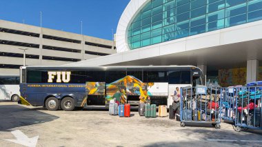 Miami, Florida, ABD - 4 Ocak 2024: Valiz Miami Limanı 'ndaki Norveç yolcu hattı terminalinde bir tur otobüsünden indiriliyor.