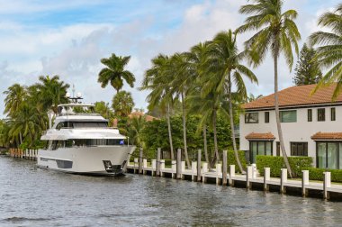 Fort Lauderdale, Florida, ABD - 2 Aralık 2023: Lüks yat Fort Lauderdale rıhtımında özel iskelesi olan bir evin yanında demirlemiş..