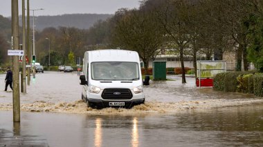 Treforest Industrial Estate, Wales, İngiltere - 24 Kasım 2024: Van, Treforest Endüstri Bölgesi 'nde sel basmış bir yolda fırtına Bert' ten sağanak yağmurun ardından suyla ilerliyor.