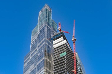 Londra, İngiltere, İngiltere - 22 Haziran 2023: Londra 'da ofis ve dairelerin yeni bir gökdelen inşaatında çalışan kule vinçleri