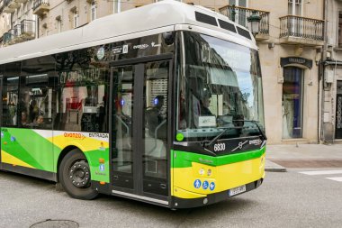 Vigo, İspanya - 14 Ocak 2025: Vigo şehrinin dar sokaklarından birinden geçen kamu hizmeti otobüsü