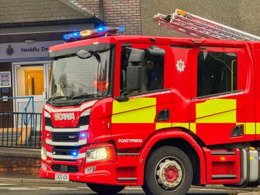 Pontypridd, Galler, İngiltere - 24 Kasım 2024: Güney Galler İtfaiye ve Kurtarma Servisi 'nin itfaiye aracı şehir merkezindeki acil bir çağrı üzerine mavi ışıklar yanıp sönüyor