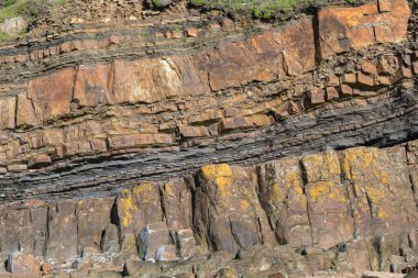 Rock strata on a cliff face. No people. Backgrounds.
