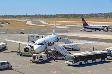 Luqa, Malta - 7 Ağustos 2023: Malta Uluslararası Havaalanına vardıktan sonra Fransız havayolu Amelia International tarafından işletilen Airbus A319 yolcu uçağından inen insanlar (ruhsat F-HDSJ).