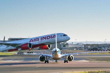 Londra, İngiltere, İngiltere - 3 Ocak 2025: Bir Air India Airbus A350 kalkmak üzereyken Londra Heathrow Havaalanı 'ndaki pistlerden birini geçmek için bekleyen küçük yolcu jeti.