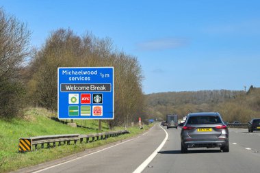 Gloucestershire, İngiltere, İngiltere - 29 Mart 2025: M5 otoyolunda trafik, sürücülerin Michaelwood servislerine olan mesafelerini gösteren bir bilgi levhasından geçiyor
