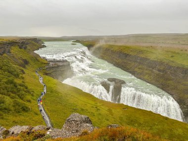 Gulfoss Şelalesi, İzlanda - 31 Ağustos 2024: Islak bir günde İzlanda 'nın güneybatısındaki Gullfoss şelalesini ziyaret eden insanların manzarası