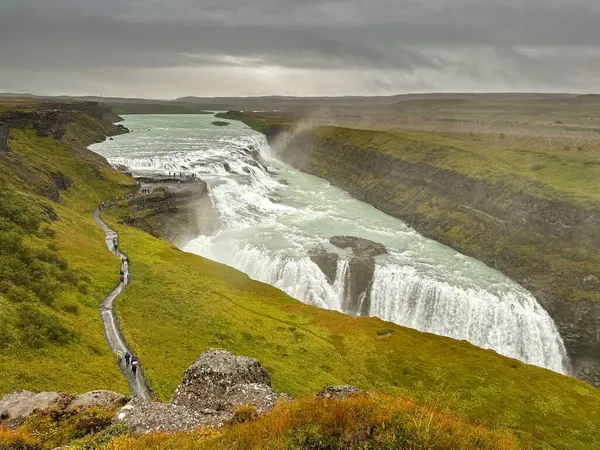 Gulfoss Şelalesi, İzlanda - 31 Ağustos 2024: Islak bir günde İzlanda 'nın güneybatısındaki Gullfoss şelalesini ziyaret eden insanların manzarası