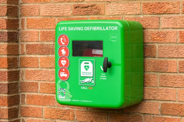 Lydney, İngiltere, İngiltere - 29 Mart 2025: Bir kamu binasının duvarındaki bir kutuda acil durum kalp defibrilatörünü yeniden başlatan bir hayata yakından bakın