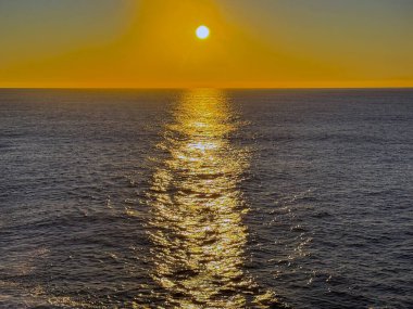 Alacakaranlıkta bir yolcu gemisinden deniz üzerinde altın güneş. Seyahat kavramı.