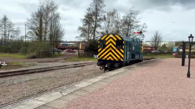 Lydney, Gloucestershire, İngiltere 30 Mart 2025: Demiryolu Mavi Ahırında klasik dizel lokomotif 08 sınıfı Dean Ormanı 'ndaki vagonları almak için bir platforma yaklaşıyor.