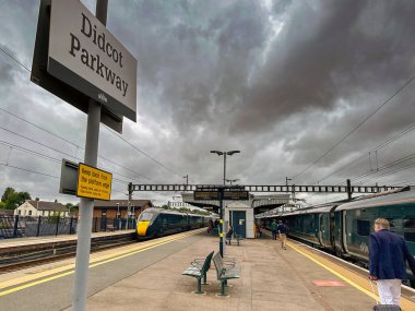 Didcot, Oxfordshire, İngiltere - 3 Temmuz 2024: Didcot Park İstasyonu 'na vardıktan sonra peron boyunca tekerlekli bavul çeken kişi,