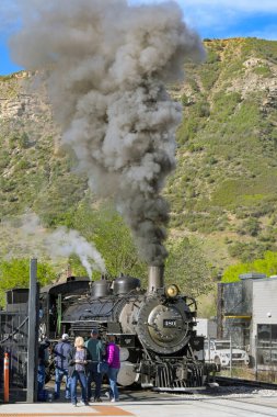 Durango, Colorado, ABD - 23 Mayıs 2025: Durango ve Silverton dar gösterge demiryollarındaki eski bir buhar makinesinin bacasından siyah duman.