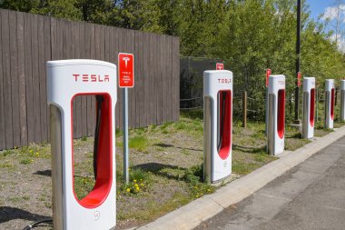 Batı Yellowstone, Montana, ABD - 30 Mayıs 2025: Batı Yellowstone 'daki bir otoparkta Tesla elektrikli arabaları için hızlı şarj istasyonları sırası.