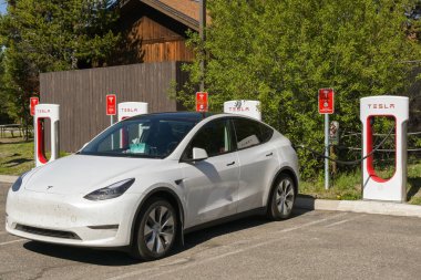 Batı Yellowstone, Montana, ABD - 31 Mayıs 2025: Tesla elektrikli araba batı Yellowstone 'daki bir otoparkta hızlı şarj istasyonuna bağlandı.