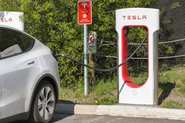 Batı Yellowstone, Montana, ABD - 31 Mayıs 2025: Tesla elektrikli araba batı Yellowstone 'daki bir otoparkta hızlı şarj istasyonuna bağlandı.