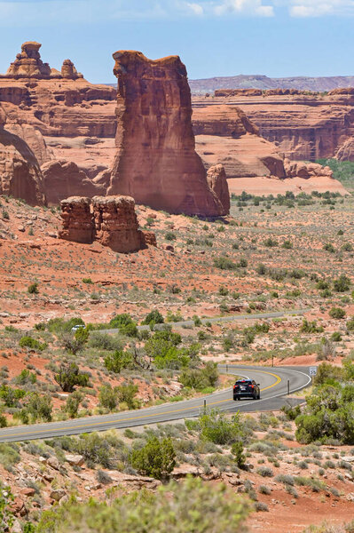 Moab, Utah, USA - 25 May 2025: Car driving through spectacular landscape scenery in the Arches National Park in Moab