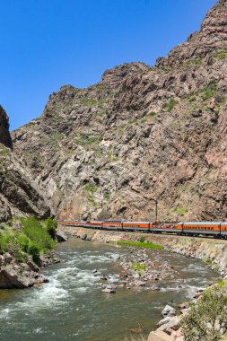 Canon City, Colorado, ABD - 22 Mayıs 2025: Arkansas Nehri 'nden geçerek vadiye giden Royal Gorge Demiryolu üzerindeki bir trenin manzarası.