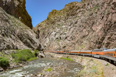 Canon City, Colorado, ABD - 22 Mayıs 2025: Arkansas Nehri 'nden geçerek vadiye giden Royal Gorge Demiryolu üzerindeki bir trenin manzarası.