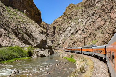 Canon City, Colorado, ABD - 22 Mayıs 2025: Arkansas Nehri 'nden geçerek vadiye giden Royal Gorge Demiryolu üzerindeki bir trenin manzarası.