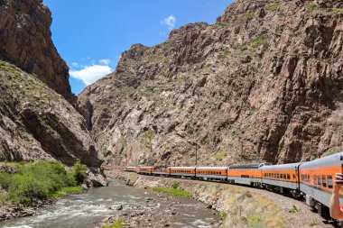 Canon City, Colorado, ABD - 22 Mayıs 2025: Arkansas Nehri 'nden geçerek vadiye giden Royal Gorge Demiryolu üzerindeki bir trenin manzarası.