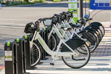 Ogden, Utah, ABD - 27 Mayıs 2025: Greenbike tarafından işletilen bisiklet paylaşım sisteminin otoparkından kiralanmış bisikletleri toplayan insanlar