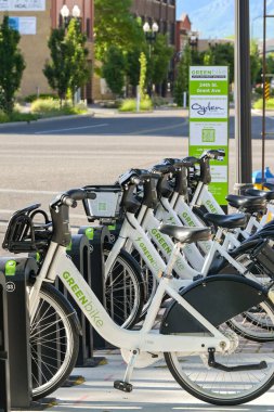 Ogden, Utah, ABD - 27 Mayıs 2025: Greenbike tarafından işletilen bisiklet paylaşım sisteminin otoparkından kiralanmış bisikletleri toplayan insanlar
