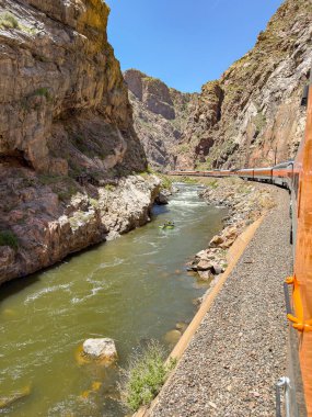 Canon City, Colorado, ABD - 22 Mayıs 2025: Royal Gorge Route Demiryolu üzerinde Arkansas Nehri 'nin yanında kano sahipleri ile birlikte akan bir trenin manzarası