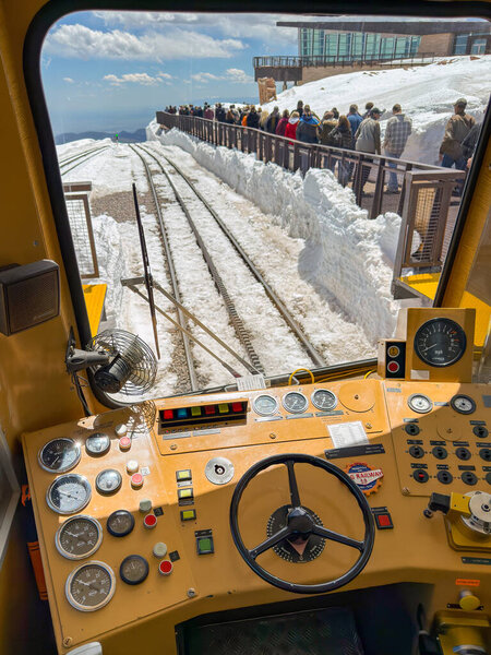 Manitou Springs, Colorado, USA - 21 May 2025: People leaving the platform of the Manitou and Pike's Peak Cog railway at the station at the summit of the Pike's Peak mountain seen through the window of the driver's cab