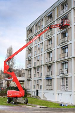 Le Havre, Fransa - 16 Ocak 2025: Le Havre şehir merkezinde bir apartman bloğunun bakımını üstlenen kiraz toplayıcı hidrolik platformdaki işçiler