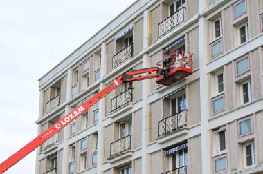 Le Havre, Fransa - 16 Ocak 2025: Le Havre şehir merkezinde bir apartman bloğunun bakımını üstlenen kiraz toplayıcı hidrolik platformdaki işçiler