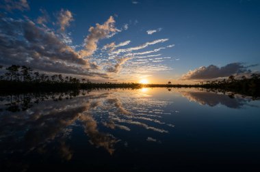 Colorful twilight cloudscape over and reflected in Pine Glades Lake in Everglades National Park, Florida..